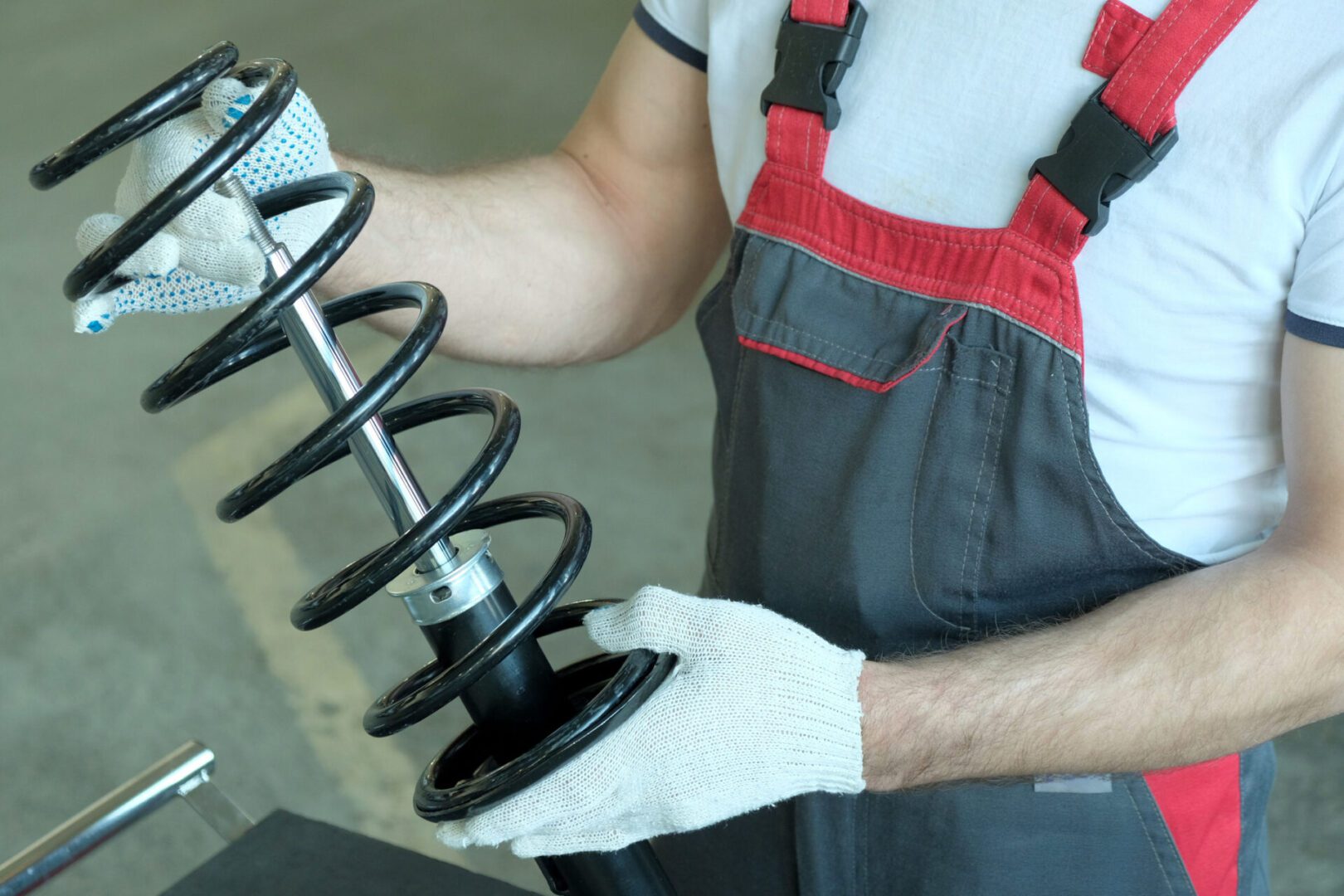 Worker inspecting automotive shock absorber