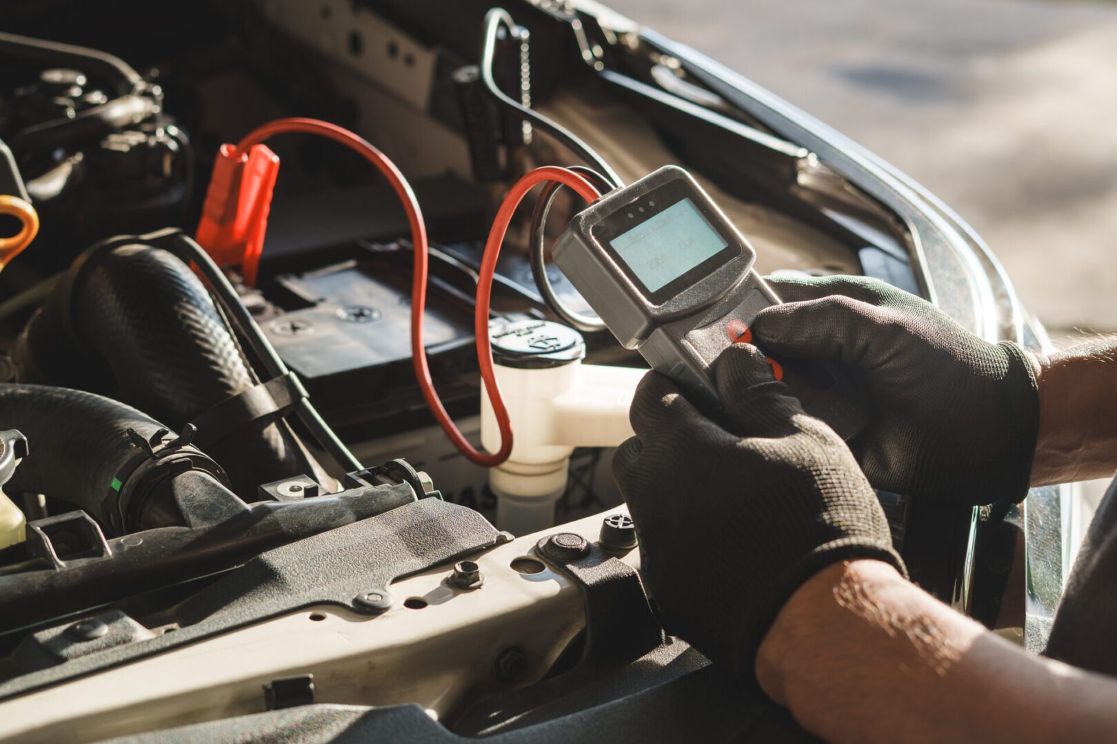 Mechanic testing car battery voltage